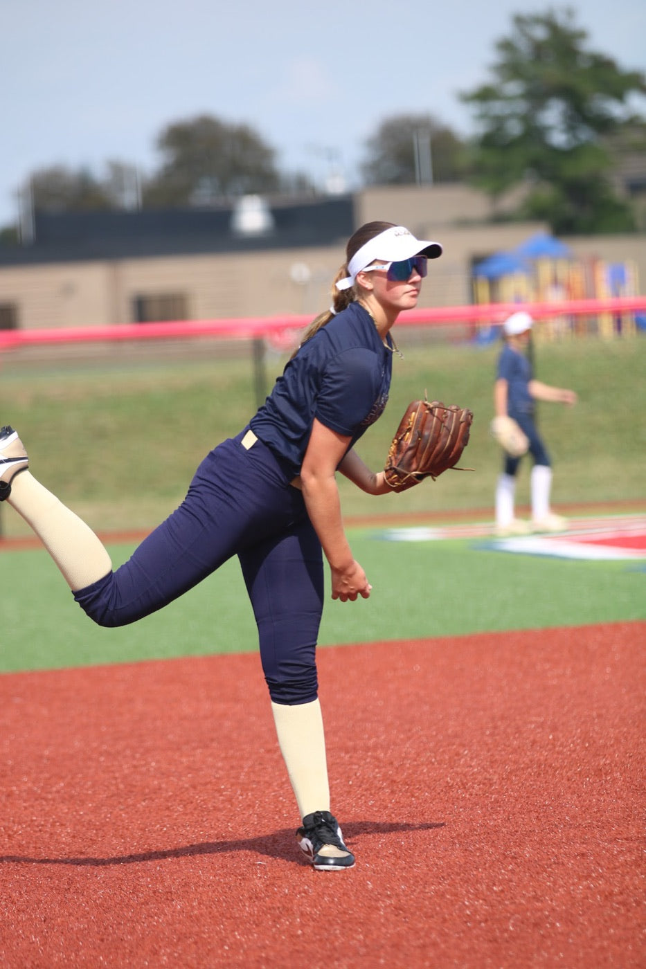 Softball athlete finishing her throw during a game