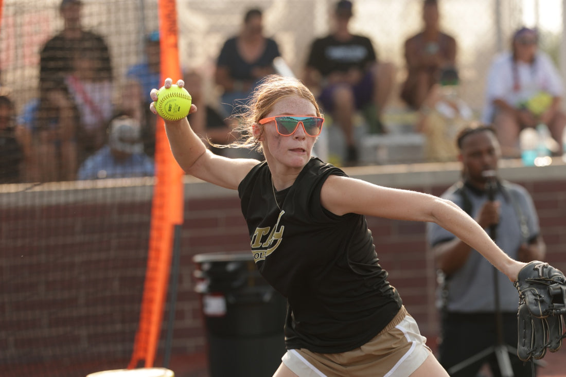 Young softball athlete mid-throw, ball in hand and glove side extended